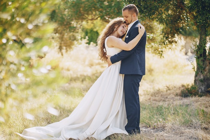 Bride and Groom embracing in a field
