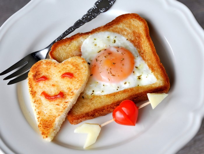 Heart-shaped toast with fried egg and tomato skewer