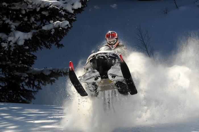 Snowmobiler jumping in the snow