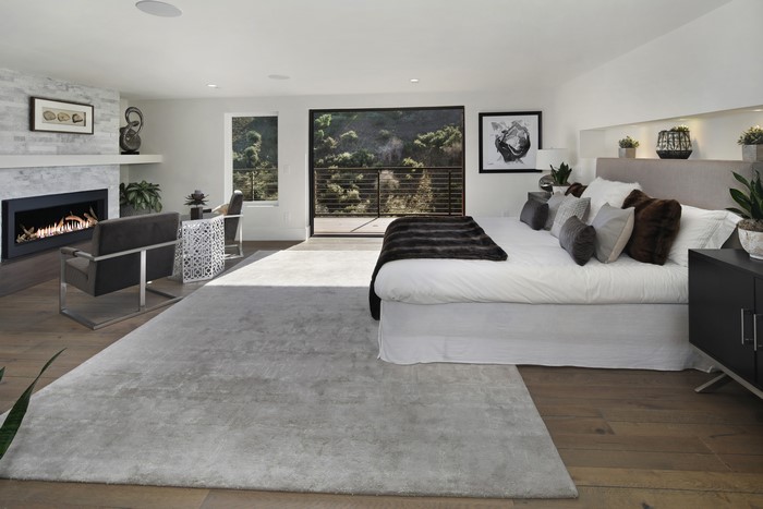 Bedroom with fireplace and balcony view