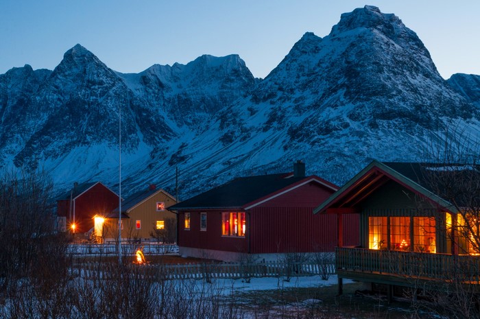 Svensby village houses at dusk with snowy mountains in Norway