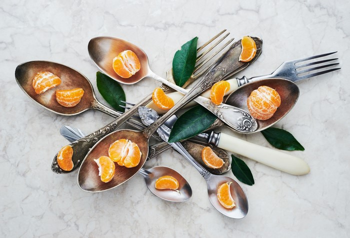 Spoons and forks with mandarin slices