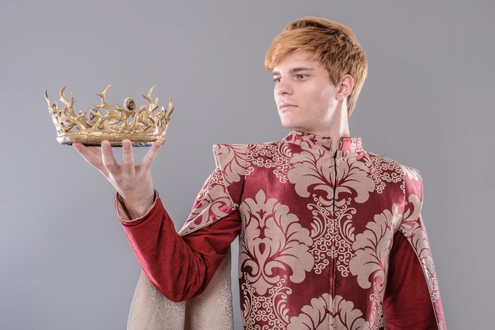 Man in ornate costume holding a crown