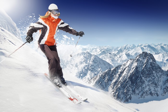 Woman skiing down a snowy mountain