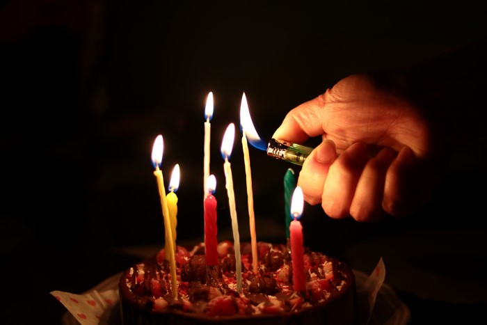 Hand lighting birthday cake candles