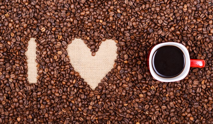Coffee beans forming I love heart with coffee cup