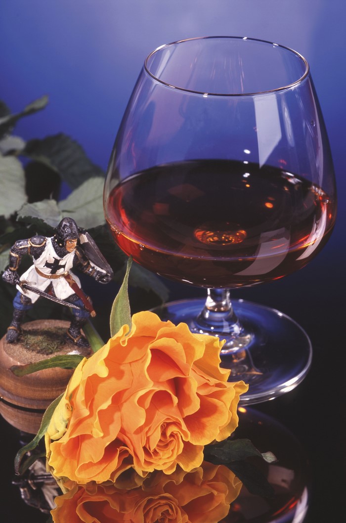 Knight figurine, brandy glass, and orange rose