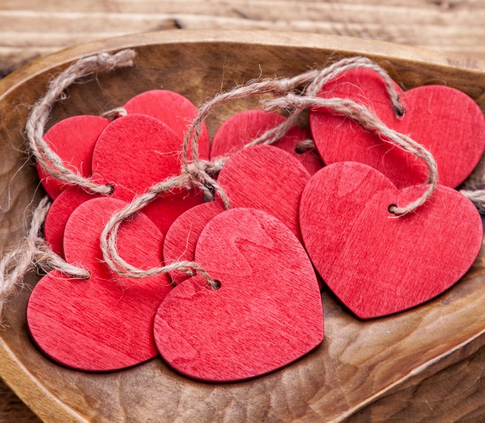 Red wooden hearts with twine in a bowl