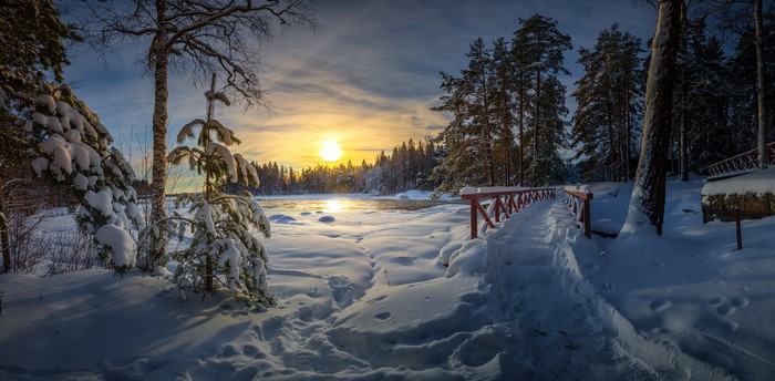 Winter sunset over a snowy landscape with a bridge