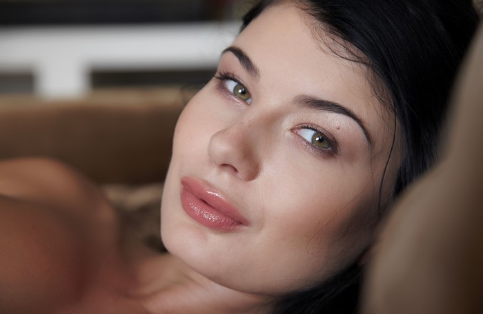 Brunette girl's face with green eyes and lips