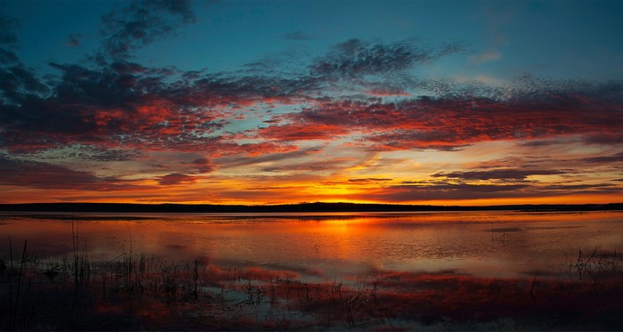 Sunset over a calm lake with colorful clouds