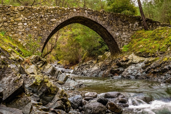 Stone arch bridge over a rocky stream