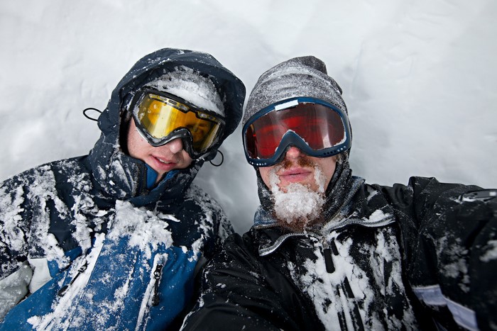 Two men in snow with ski goggles