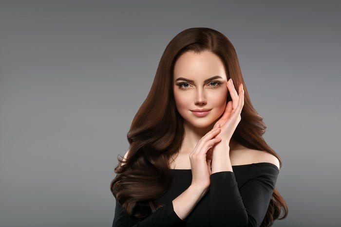 Beautiful woman with brown hair on gray background