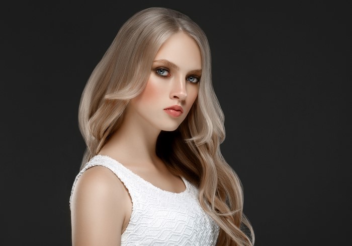 Blonde woman with wavy hair on black background
