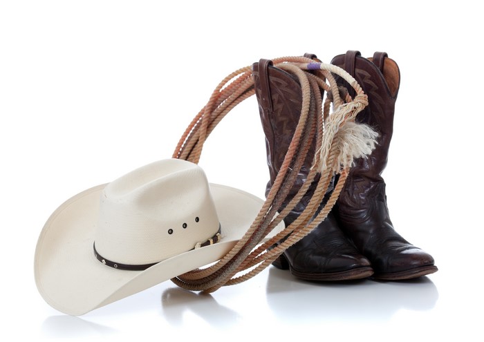 Cowboy hat, boots, and rope on white background
