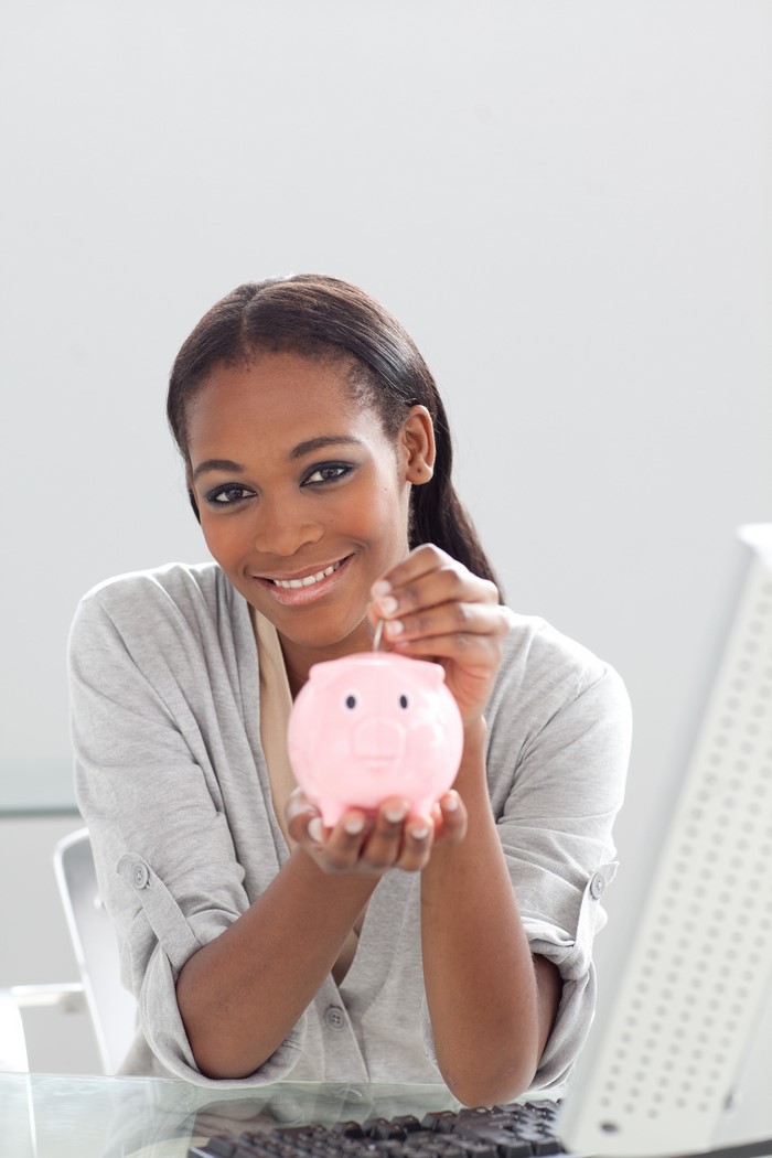 Young woman saving money in a piggy bank