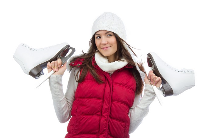 Woman in winter hat holding ice skates