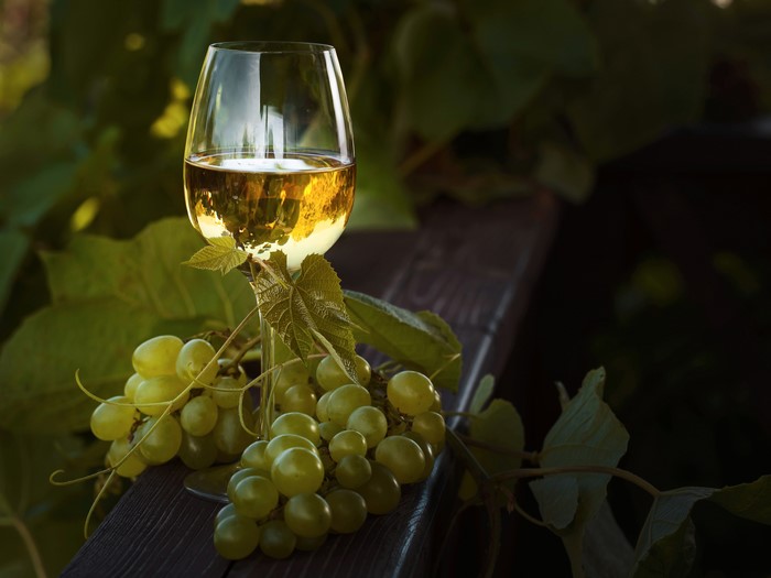 Glass of white wine with green grapes