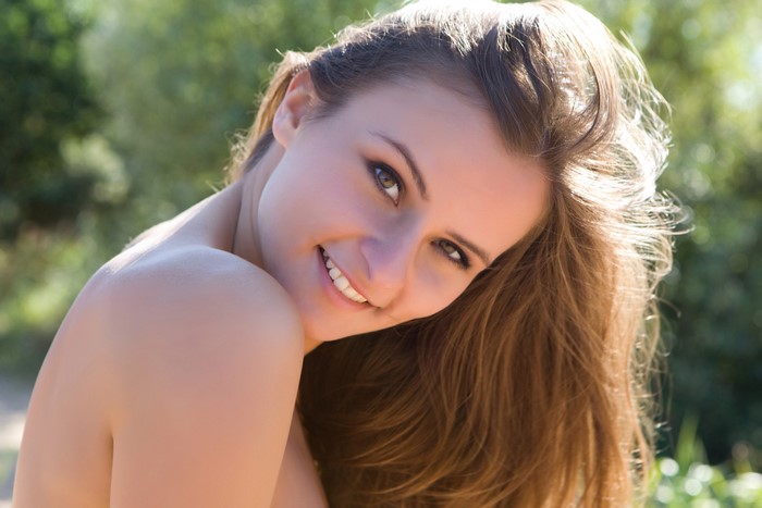 Brown haired woman smiling outdoors