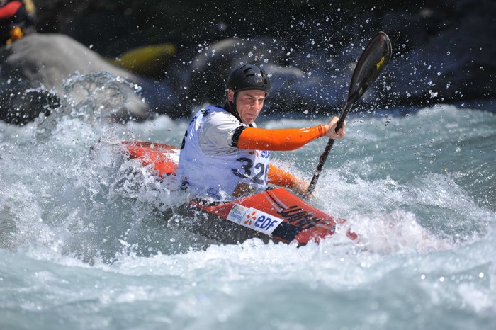 Man in Kayak Paddling Through Water Splash
