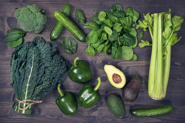 Assortment of fresh green vegetables on a wooden surface