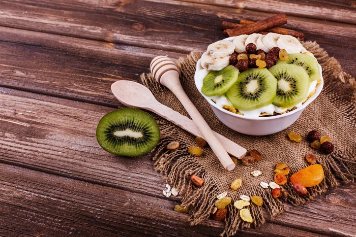 Muesli with Kiwi, Banana, and Raisins on Wood