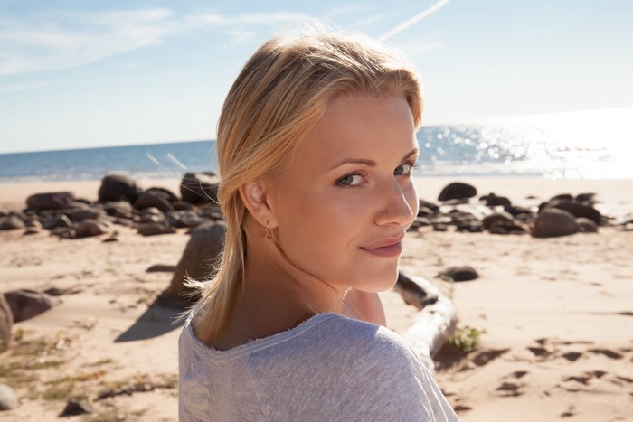 Blonde woman looking over her shoulder on a beach