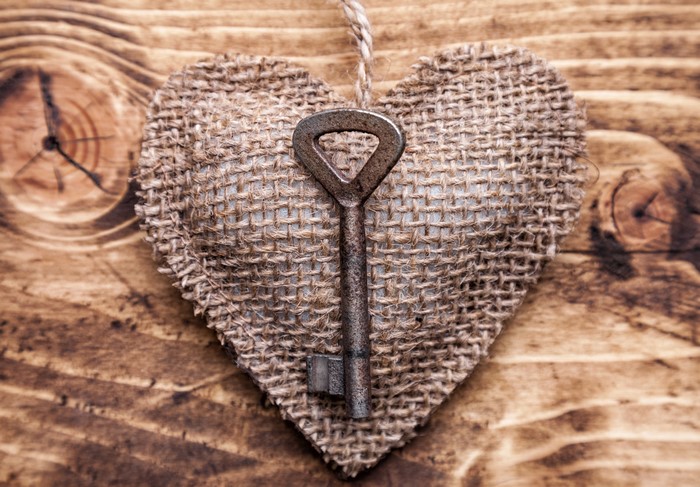 Heart shape with key on wooden background