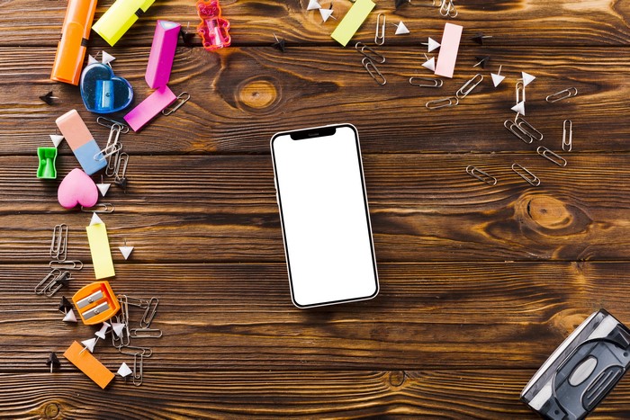 Smartphone and stationery on wood planks