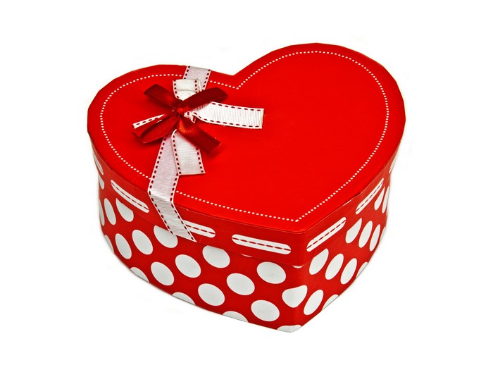 Red heart-shaped gift box with white polka dots and ribbon