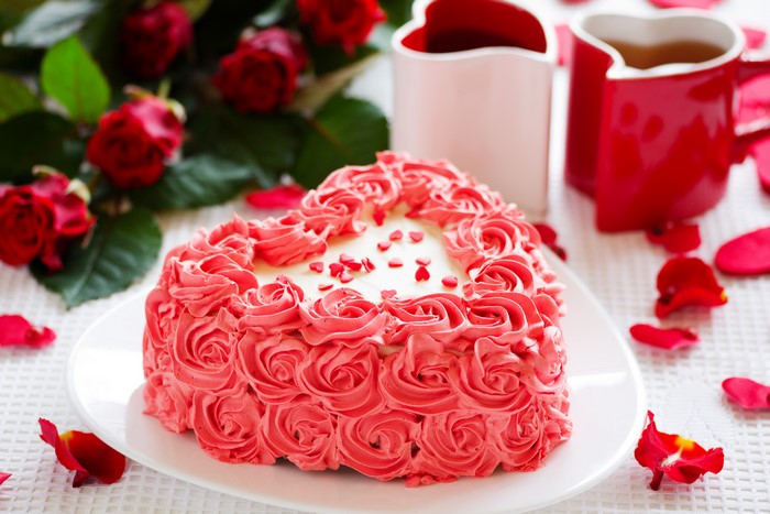 Heart-shaped cake with roses and red roses