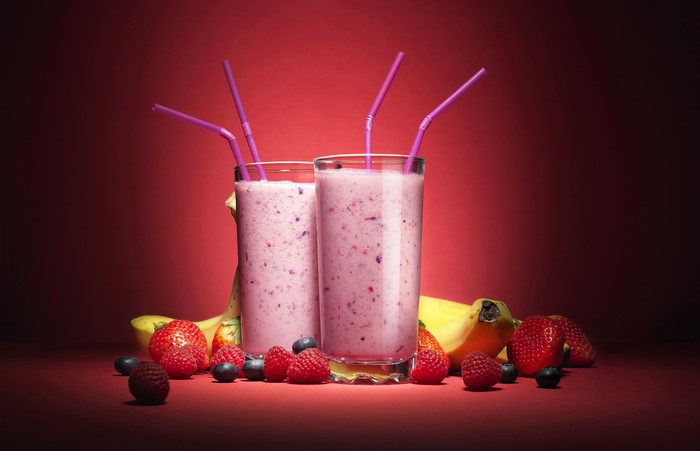 Two berry smoothies with strawberries, raspberries, blueberries, and bananas