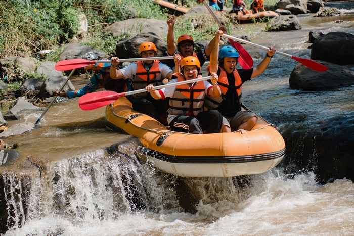 Men Rafting Down a River