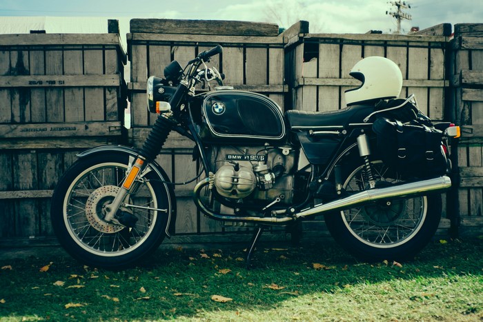 BMW R90/6 Motorcycle with Helmet and Wooden Fence