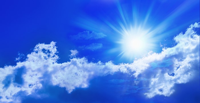 Sun shining brightly in a blue sky with clouds