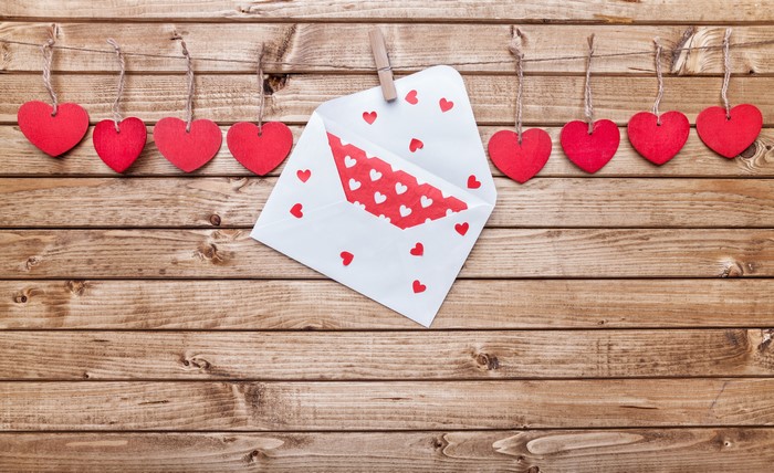 Valentine's Day hearts and envelope on wood planks