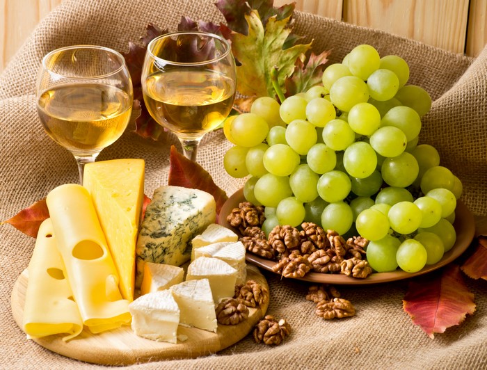 Wine, Grapes, Cheese, and Nuts on a Burlap Background