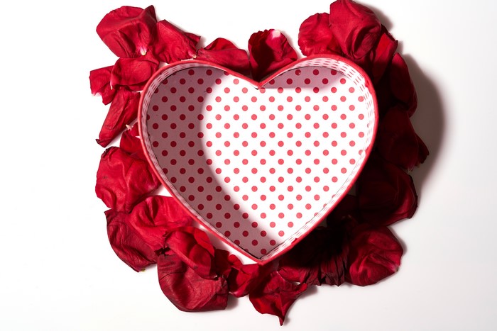Heart-shaped box with red rose petals