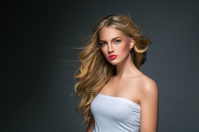 Blonde woman with flowing hair and pink lipstick