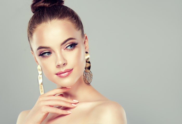 Woman with brown hair and gold earrings