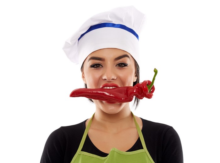 Woman in chef hat with red pepper