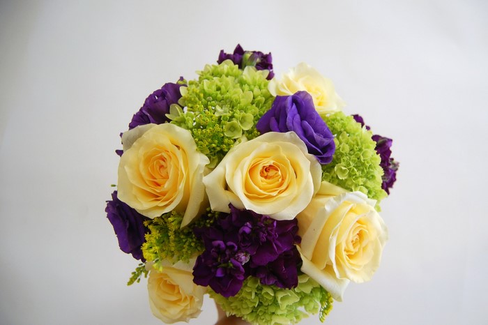 Bouquet of yellow roses, purple lisianthus, and green hydrangeas