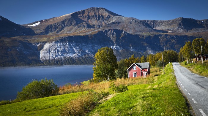 Red house by Ullsfjorden with mountains in Norway