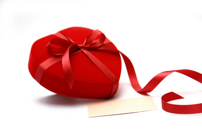 Red heart-shaped gift box with ribbon and card