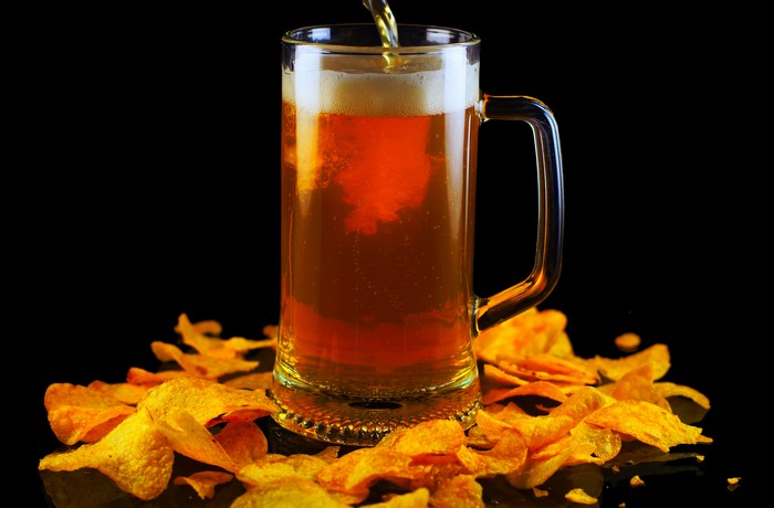 Beer mug with chips on black background