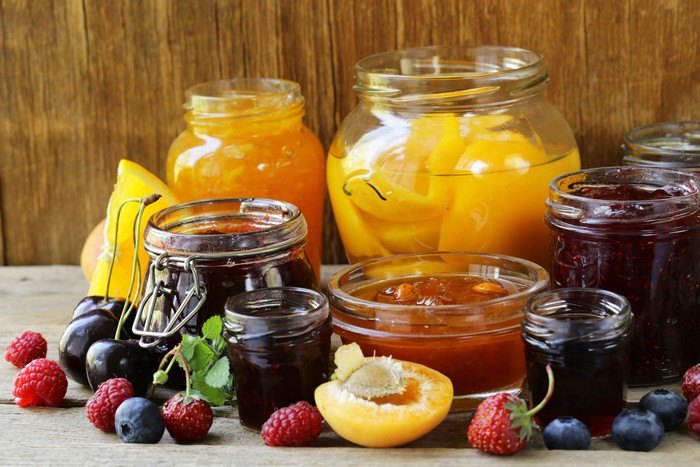 Jars of jam with fresh berries and fruit