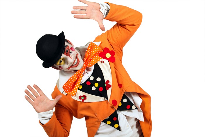 Clown in orange suit with makeup and hat