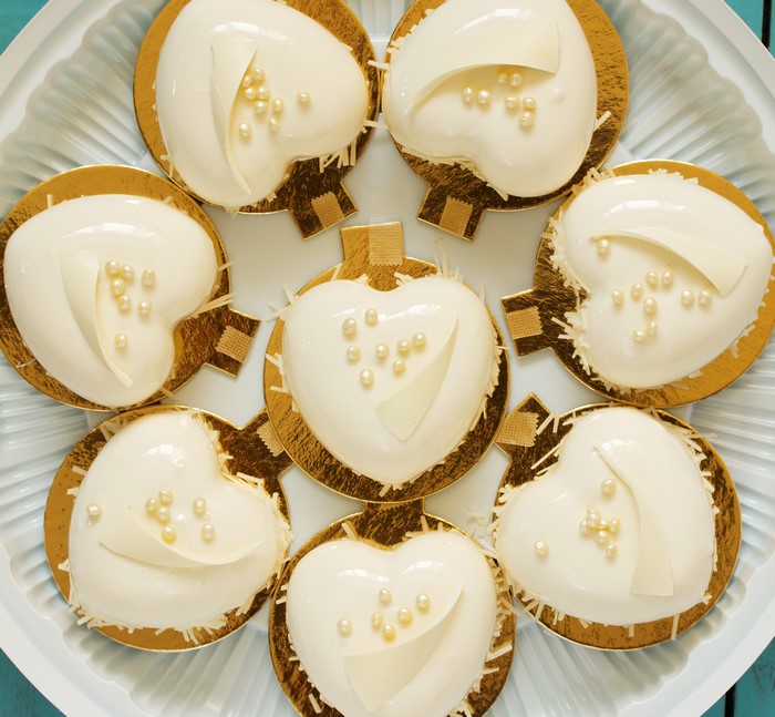 Heart-shaped white cakes with pearls and chocolate