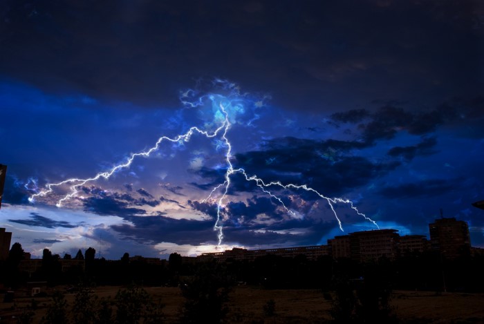 Lightning strikes over a city at night